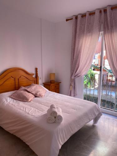 a bedroom with a bed with towels and a window at Los Hidalgos Golf 7 in Manilva