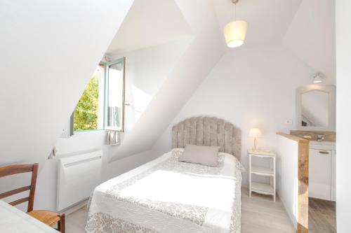 une chambre blanche avec un lit et une fenêtre dans l'établissement La Misaine, à Pierrefitte-en-Auge