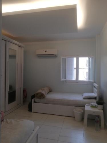 um quarto branco com uma cama e uma janela em غرفة مفروشة خاصة الشيخ زايد للرجال فقط em Sheikh Zayed