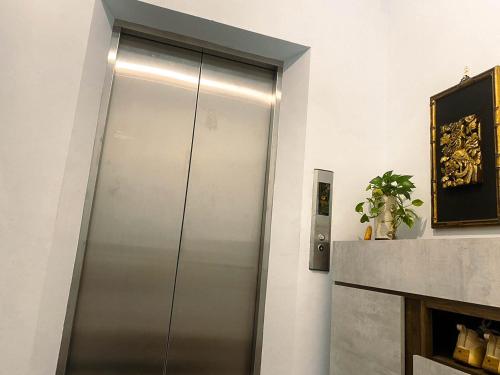un ascensor de acero inoxidable en una habitación en 慢時光中興時尚青公寓, en Nantou City