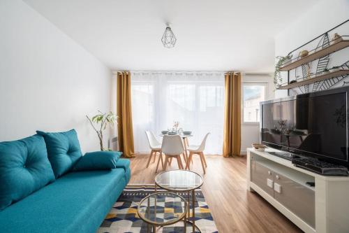 ein Wohnzimmer mit einem blauen Sofa und einem Tisch in der Unterkunft Le Nid Douillet T2, Wifi, Parking privé gratuit in Lille