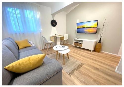 a living room with a blue couch and a tv at Apartments Fantasia in Pula
