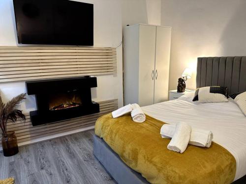a bedroom with a large bed with a fireplace at Stratford Stay - sleeps up to 9 near City Centre with parking in Birmingham
