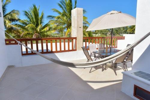 a hammock on a patio with a table and chairs at Telchac Beach House in Telchac Puerto
