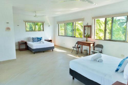 a bedroom with two beds and a desk and a couch at Telchac Beach House in Telchac Puerto