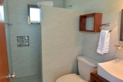 a bathroom with a shower with a toilet and a sink at Telchac Beach House in Telchac Puerto