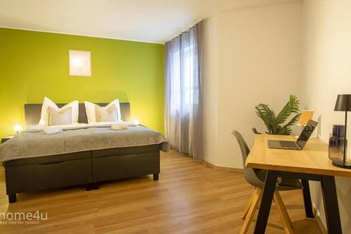 a bedroom with a bed and a desk with a laptop at Business-Apartment in Amberg