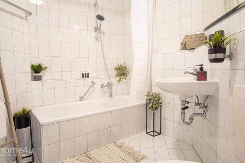 y baño con lavamanos, bañera y lavamanos. en Business-Apartment, en Amberg