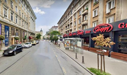 una calle de la ciudad con edificios y coches aparcados en la calle en Vintage Top Centre Apartment en Sofía