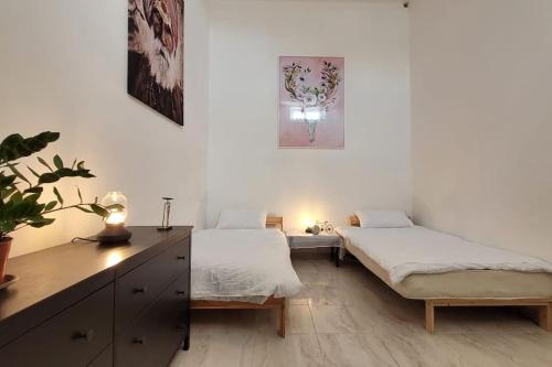 1 Schlafzimmer mit 2 Betten und einem Schreibtisch mit einer Pflanze in der Unterkunft Luxury en-suite Double. Beach-house with Sea Views in Mellieħa