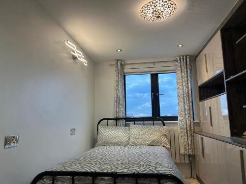 1 dormitorio con cama y ventana grande en Modern Family Home in Greater London en Pinner