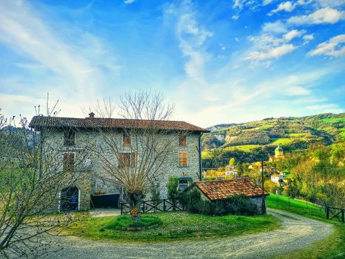 una vieja casa de piedra con un camino al lado en Agriturismo Campo Rosso, en Civitella di Romagna