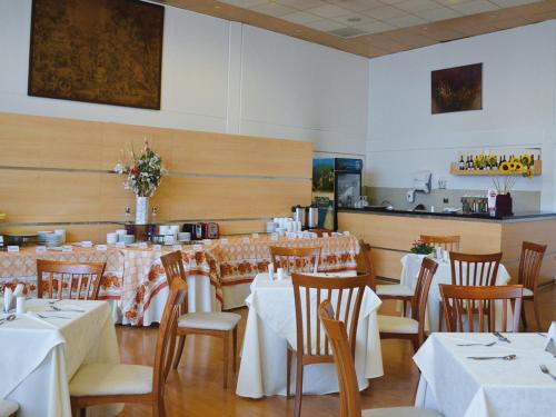 uma sala de jantar com mesas e cadeiras com toalhas de mesa brancas em Hotel Nippon y Centro de Eventos em Santiago