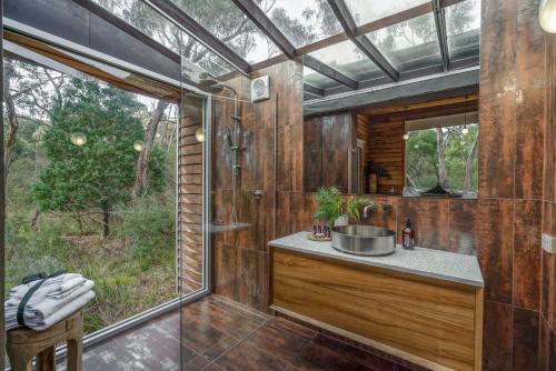 a bathroom with a sink and a glass shower at DULC Cabins in Halls Gap