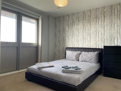 Spacious Flat in Manor House, London في لندن: غرفة نوم عليها سرير وحذيين