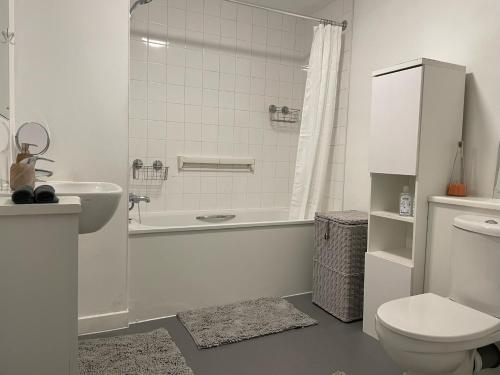 a bathroom with a tub and a toilet and a sink at Spacious Flat in Manor House, London in London