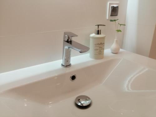 a white sink with a soap dispenser on it at Nowy w centrum 2 in Giżycko