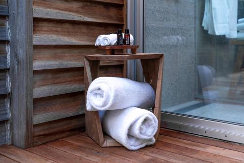 a pile of towels on a stand next to a door at DULC Cabins in Halls Gap