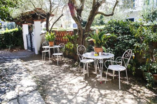 eine Gruppe von Tischen und Stühlen unter einem Baum in der Unterkunft Enzo’s House in Lucca