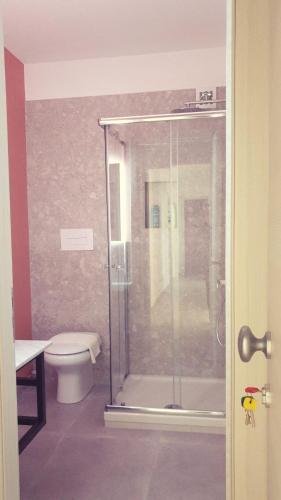 a bathroom with a toilet and a glass shower at Casa Villaggio Pirandello in Agrigento