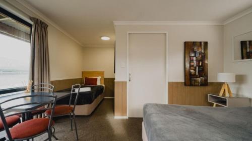 a hotel room with two beds and a table and chairs at Lakes Edge Holiday Park in Lake Tekapo