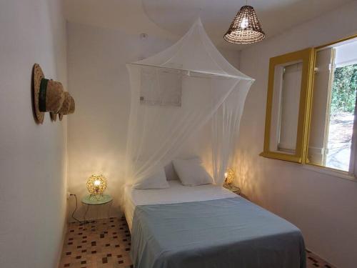 a bedroom with a bed with a mosquito net over it at Villa Sunshine in La Trinité