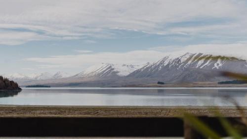 a view of a lake with mountains in the background at Lakes Edge Holiday Park in Lake Tekapo