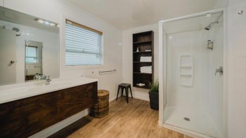 a bathroom with a shower and a sink and a mirror at Lakes Edge Holiday Park in Lake Tekapo