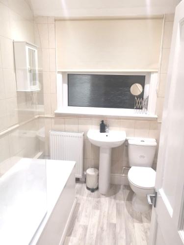 a white bathroom with a toilet and a sink at Amazing 2 bed London apartment in London