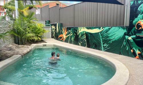 a person swimming in a swimming pool with a mural at Nambour Heights Motel in Nambour