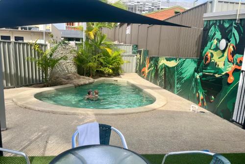 un par de personas en una piscina en Nambour Heights Motel en Nambour