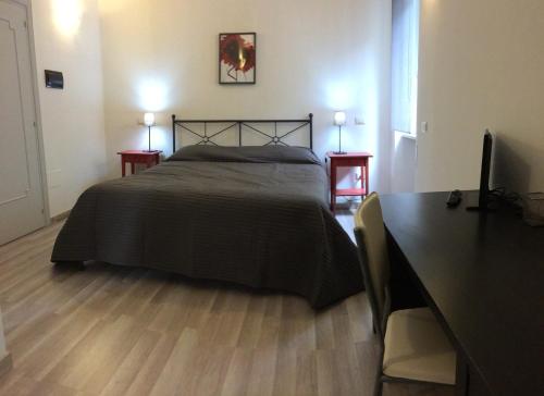 ノーヴァ・シーリ・マリーナにあるB&B Preludioのベッドルーム1室(ベッド1台、テーブル2台、デスク付)