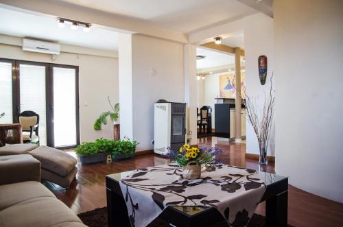 una sala de estar con una mesa con flores. en Modern Penthouse Apartment in Bitola, en Bitola