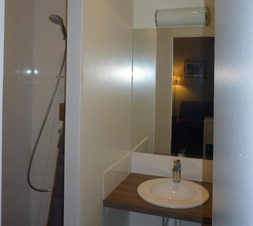 une salle de bain avec un lavabo et un miroir dans l'établissement Tour Eiffel Beaugrenelle, à Paris