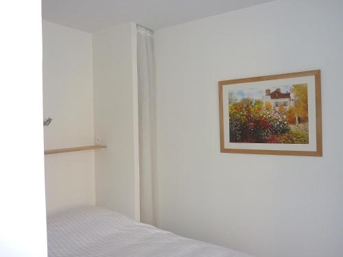 1 dormitorio con 1 cama y una pintura en la pared en Tour Eiffel Beaugrenelle, en París