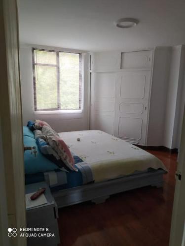 een kleine slaapkamer met een bed en een raam bij Apartamento vacacional amoblado in Armenia