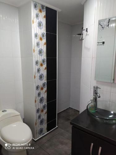 een badkamer met een toilet, een wastafel en een douche bij Apartamento vacacional amoblado in Armenia