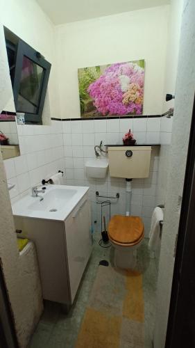 a bathroom with a sink and a toilet and a painting at Casa dragão in Porto