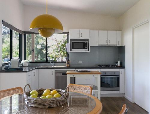 a kitchen with a table with a bowl of fruit on it at The Dairy . Margaret River in Margaret River Town