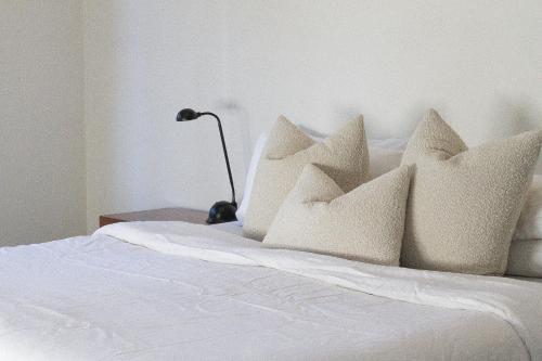 a white bed with white pillows on it at The Dairy . Margaret River in Margaret River Town