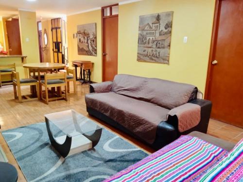 Duplex amoblado en el corazón de Ayacucho في اياكوتشو: غرفة معيشة مع أريكة وطاولة