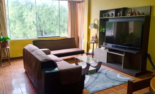 Duplex amoblado en el corazón de Ayacucho في اياكوتشو: غرفة معيشة بها أريكة وتلفزيون
