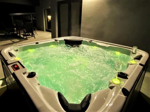 a bath tub filled with green water in a room at Country house Greenfields in Gospić
