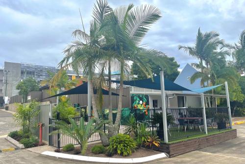 a house with a palm tree in front of it at Nambour Heights Motel in Nambour