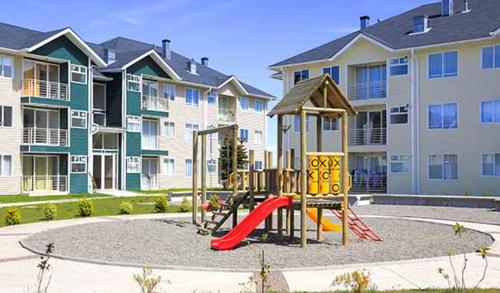 un parque infantil frente a un complejo de apartamentos en Depto Maqui, en Puerto Montt
