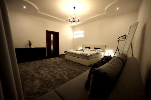 um quarto com uma cama e um sofá em Apartmány PARK em Klásterec nad Ohrí