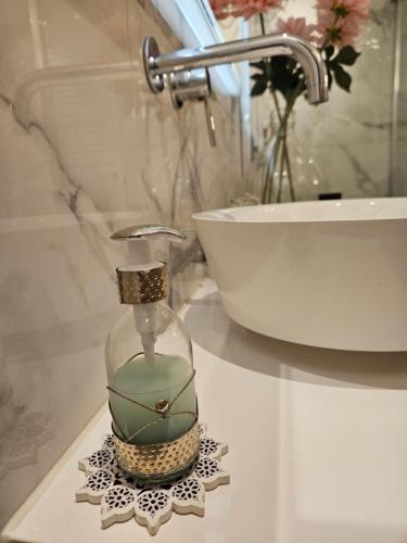 a bathroom sink with a glass soap dispenser on a counter at Amberdi Apartment Amsterdam Schiphol Airport in Hoofddorp