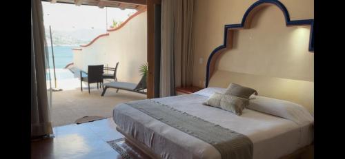 a bedroom with a bed and a view of the ocean at Villa del Pescador in Zihuatanejo
