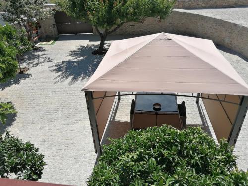 a tent with a chair under it in a garden at Casa d'Amêndoa in Felgar