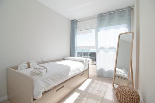 um quarto branco com um espelho e uma cama em Global Properties, Moderno apartamento con vistas a la costa mediterranea en Gran Canet em Canet d'En Berenguer